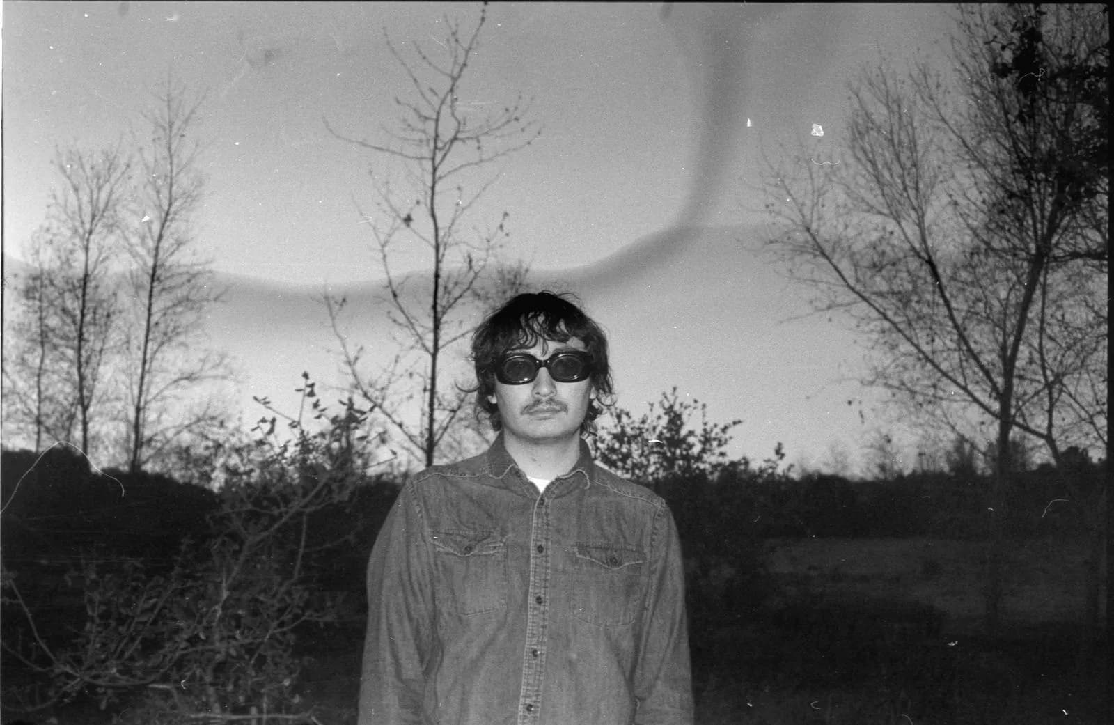 Retrato en blanco y negro de un integrante de Vertigo con lentes oscuros