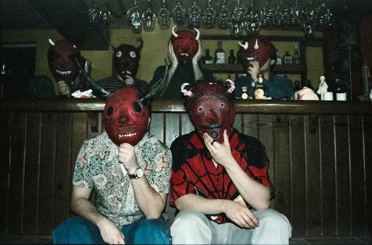 Two Vertigo members wearing handmade red masks